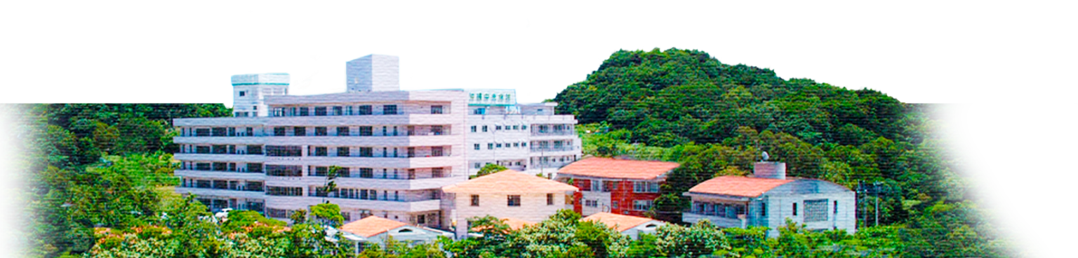 緑に囲まれた丘の上に立つ介護施設の全景。複数棟の建物が見える。